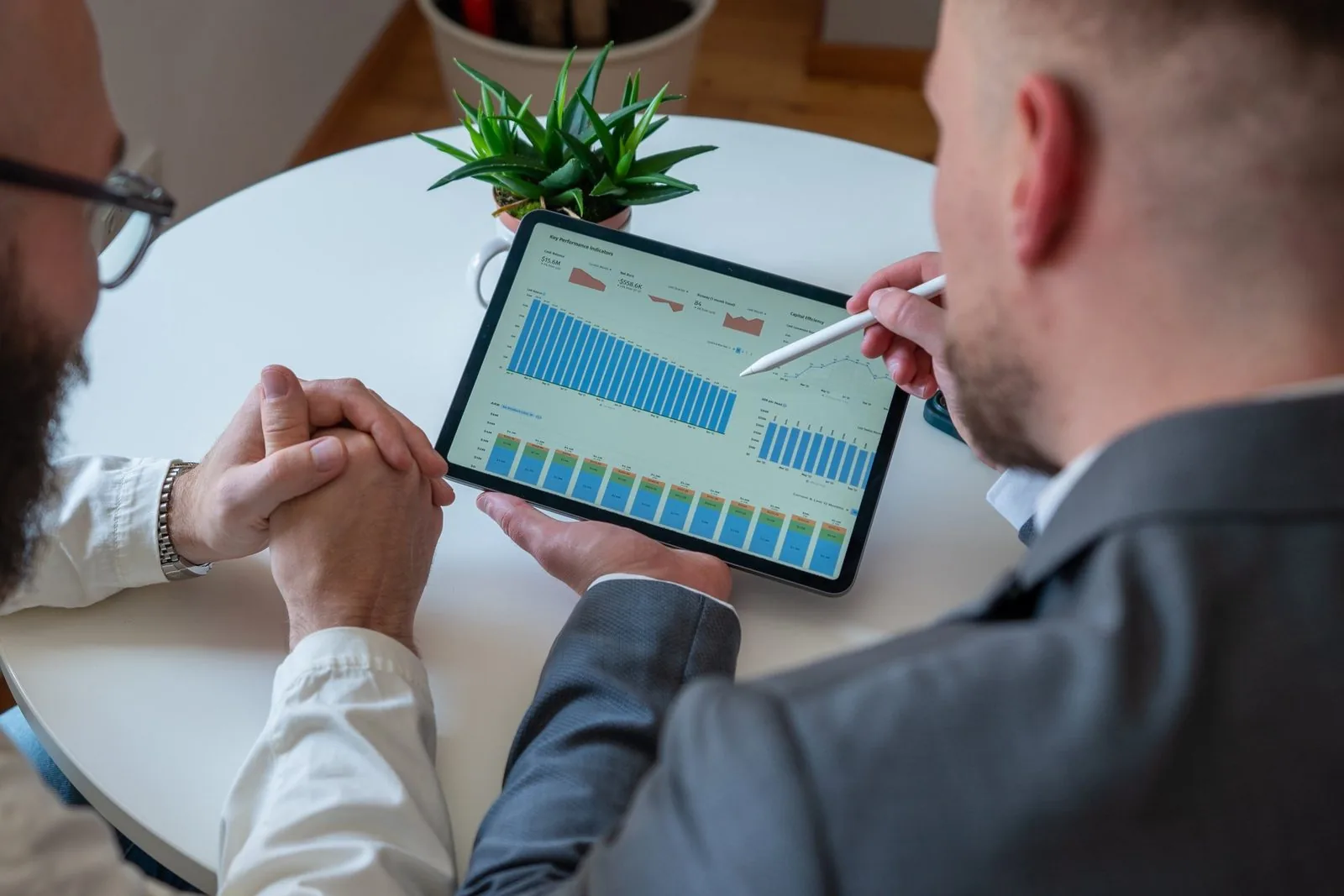 Zwei Geschäftsführer besprechen Kennzahlen auf einem Tablet